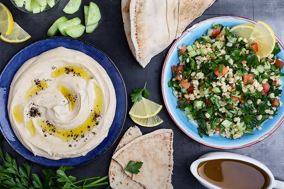 A delicious spread of Middle Eastern cuisine ideal for fasting days featuring creamy hummus, fresh tabbouleh salad, and warm pita bread, accompanied by slices of cucumber and lemon wedges.