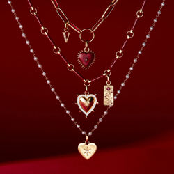 Jewellery photography - Heart necklaces hanging in front of a deep red background.