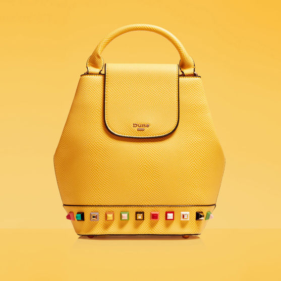Advertising photography shot by advertising photographer of a yellow Dune handbag on a yellow background