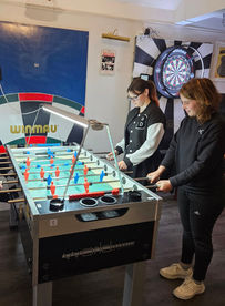 Women’s foosball team smiling and posing at Newark Foosball Club.