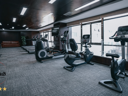 Gimnasio moderno impecablemente limpio, con suelos y máquinas relucientes y ambiente luminoso, tras un servicio profesional de limpieza especializada