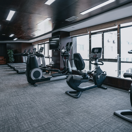 Gimnasio moderno impecablemente limpio, con suelos y máquinas relucientes y ambiente luminoso, tras un servicio profesional de limpieza especializada