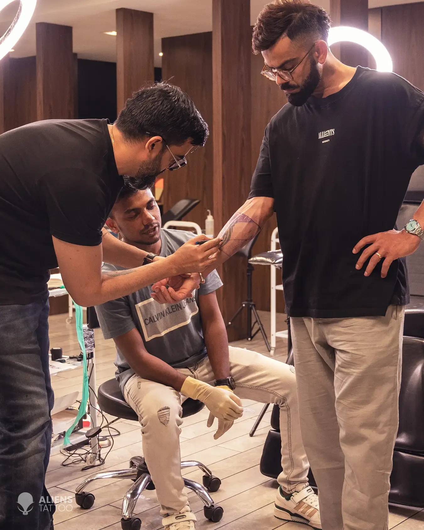 Sunny Bhanushali and Devendra Palav working on Virat Kohli's arm band tattoo.