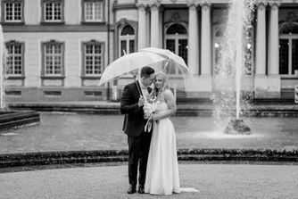 Schwarzweiß-Paarfoto mit Regenschirm vor dem Schloss Bruchsal