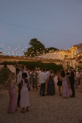 wedding guests parting in the evening outside wedding venue in the south of France beneath firelight by sam mcgregor