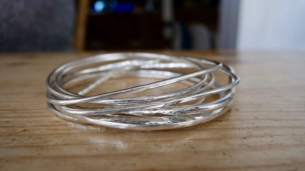 A stack of sterling silver bangles on a table
