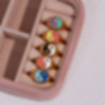 Various colorful yin yang rings displayed in a pink jewelry box 9to5Jewels.