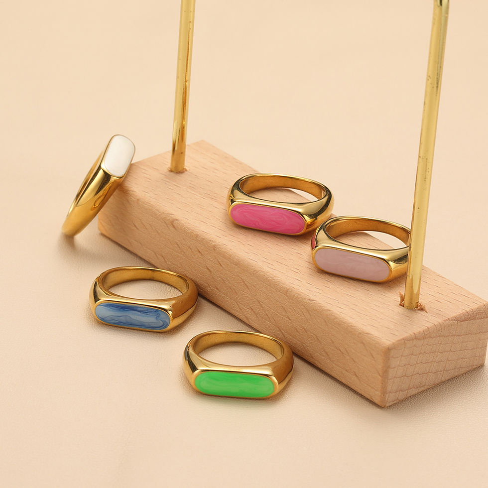 Various colorful rings displayed on a wooden stand for sale by 9to5Jewels