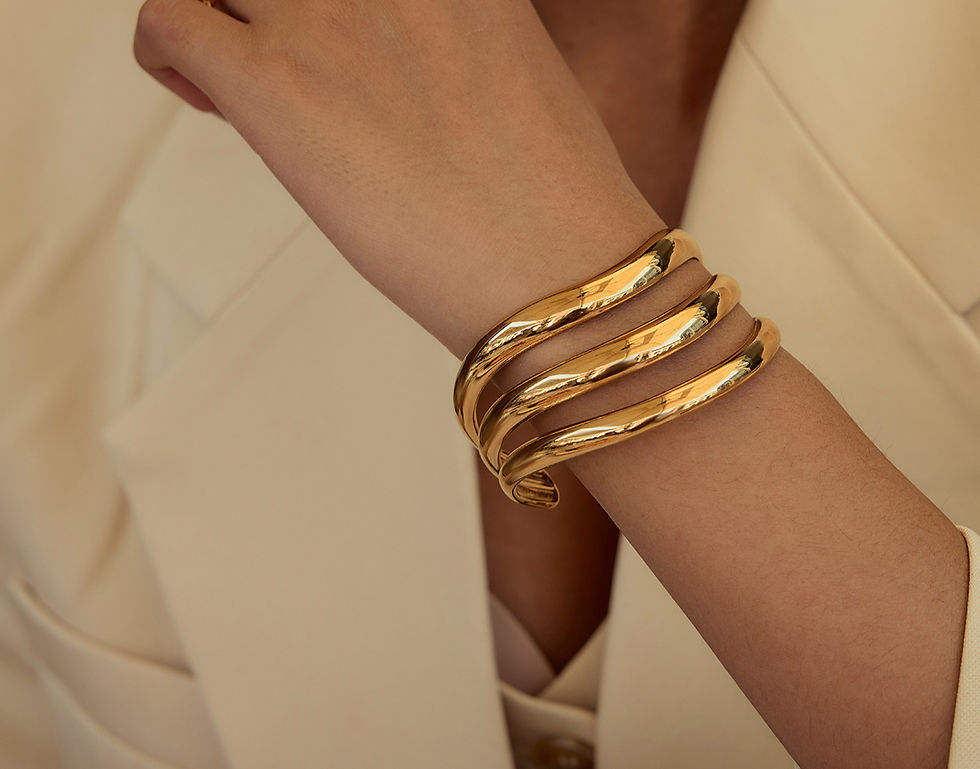 Woman's wrist wearing gold layered bracelet. Fashion statement, elegant design. 9to5Jewels.