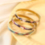 Three gold bangles with colorful mosaic design on display. 9to5Jewels.