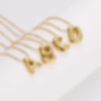 Gold necklaces spelling A, B, C, and D against a white background. 9to5Jewels.