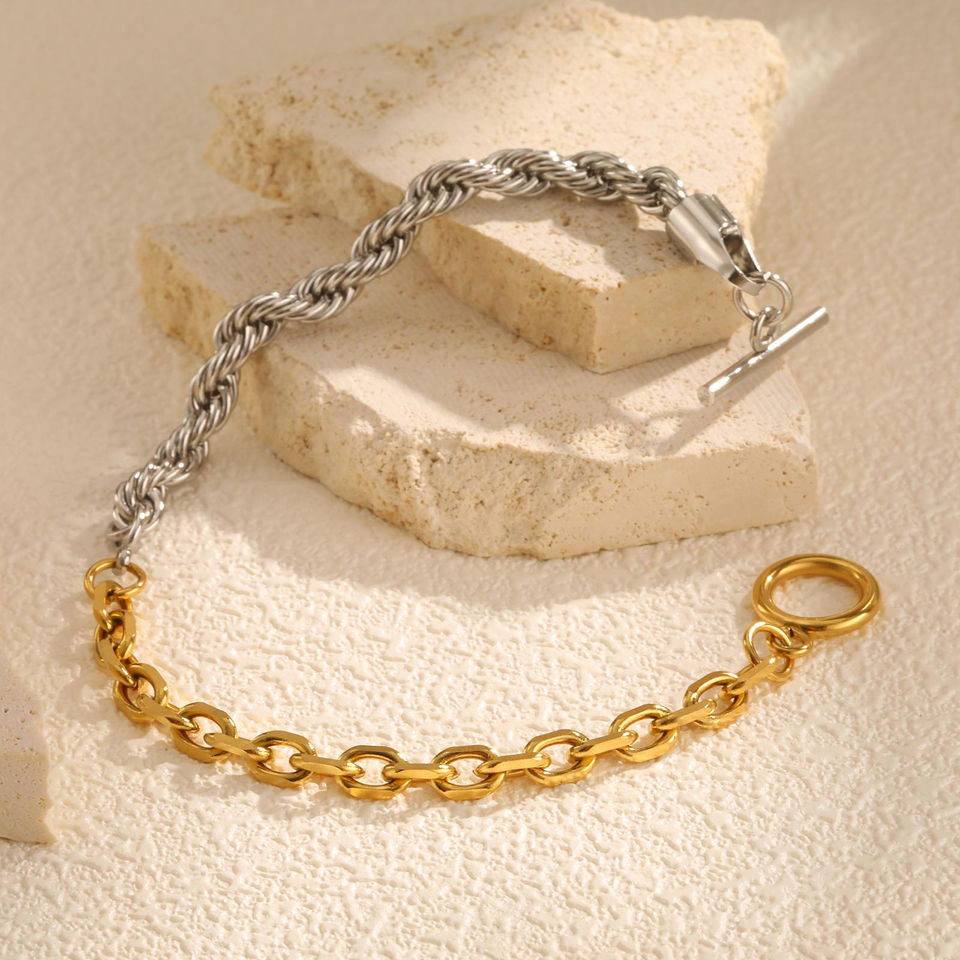 Two-tone chain bracelet, gold and silver, on a neutral stone background. 9to5Jewels