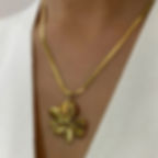 Woman wearing a gold flower pendant necklace, fashion jewelry, 9to5Jewels.
