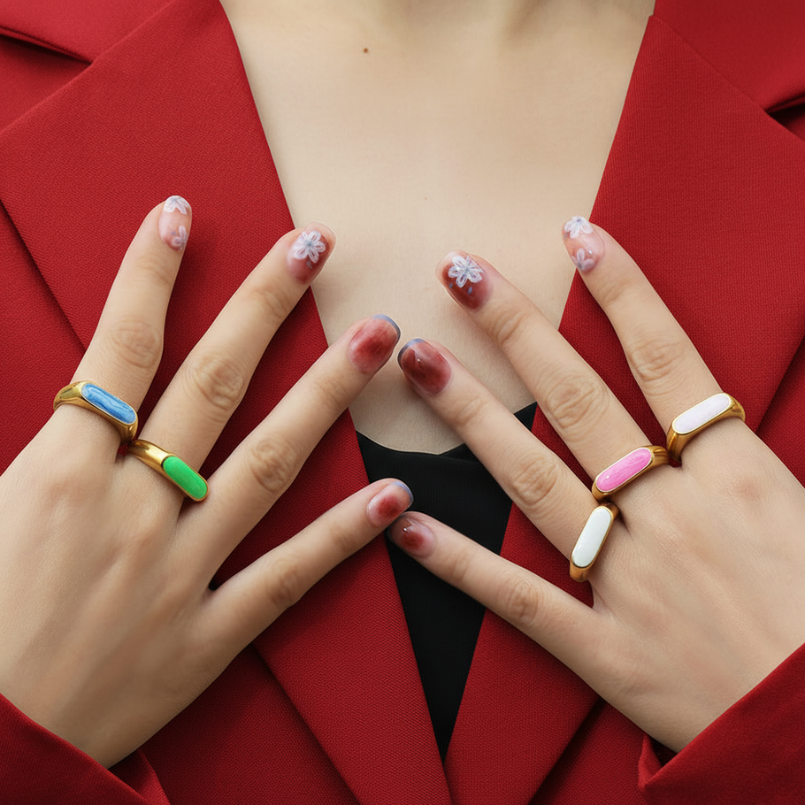 Woman's hands with colorful rings, a red blazer, and 9to5Jewels.