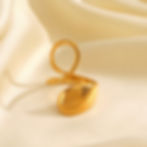 Elegant gold ring with unique loop design on a silky white backdrop, 9to5Jewels