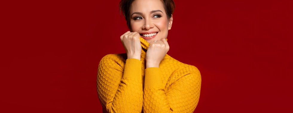 A portrait of Lea Salonga, posing in a yellow top against a red backdrop