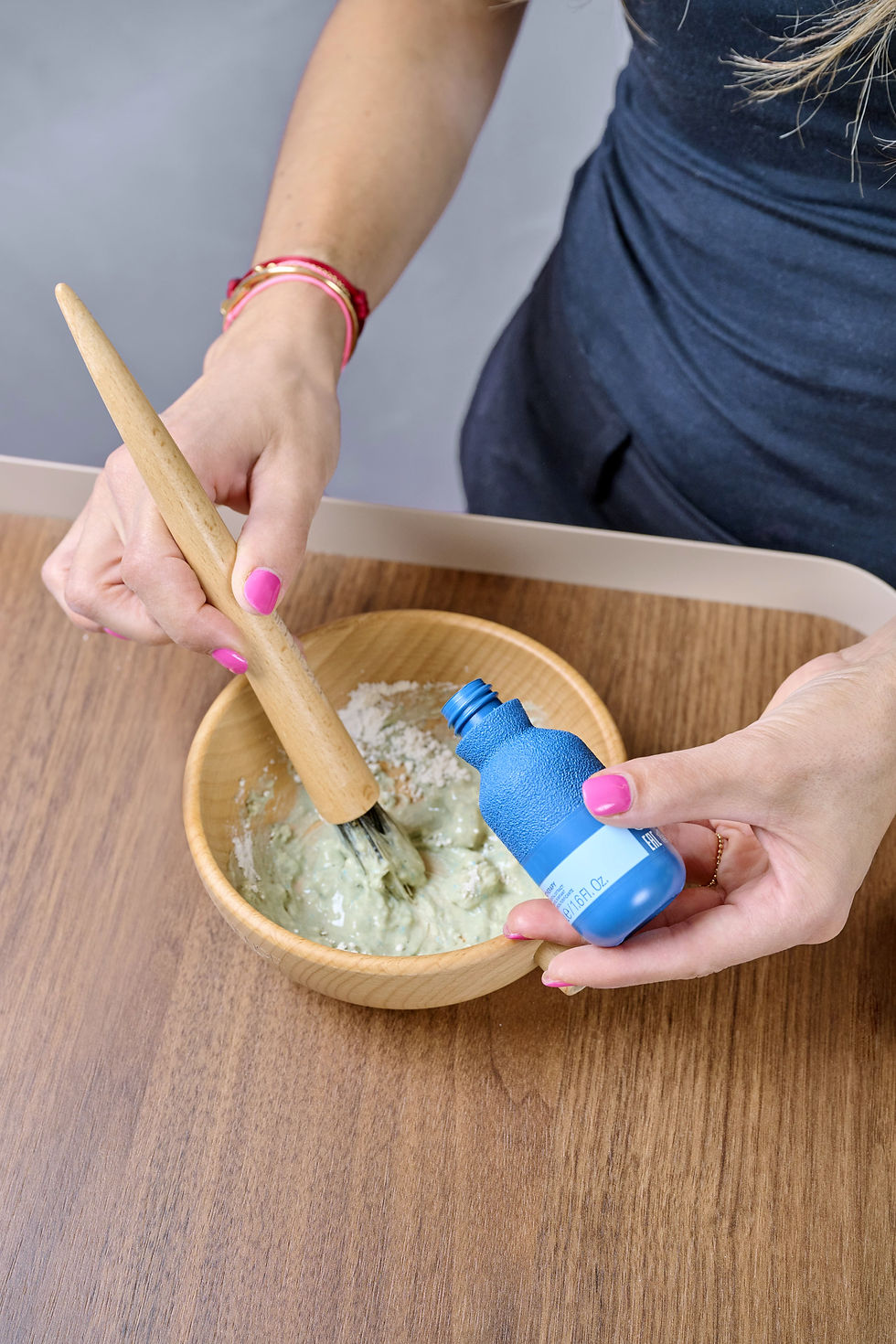 Hände mischen eine grünliche Paste an