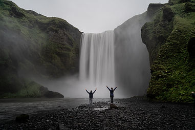 Vali & Alex standing in front of Skógafoss in Iceland