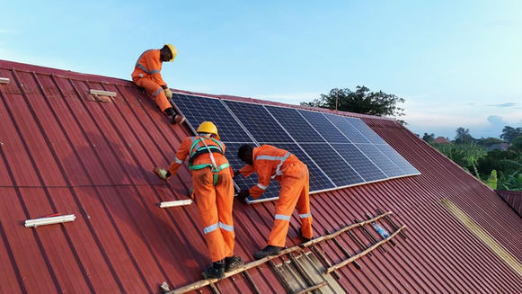 Technicians installing solar panels on a roof.