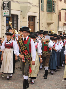 Musikkapelle in Südtiroler Tracht zieht durch die Gassen von Kaltern