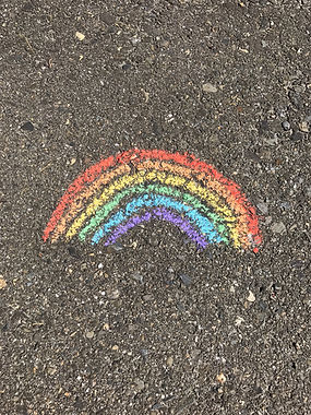 Rainbow made with chalk on asphalt.