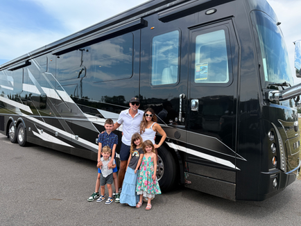 Family standing in front of a luxury Foretravel Motorcoach RV