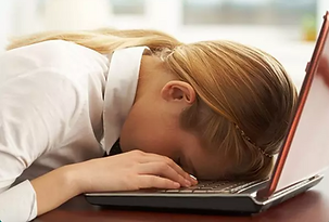 woman with her head down on the computer keyboard lookig exhausted and burned out.