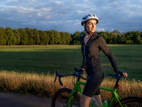 una donna in bicicletta nel mezzo della campagna