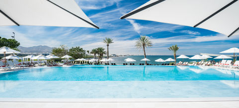 Daytime view of the inviting pool at Crowne Plaza Muscat, under clear blue skies, captured by luxury hotel photographer Herbert Fernandes.