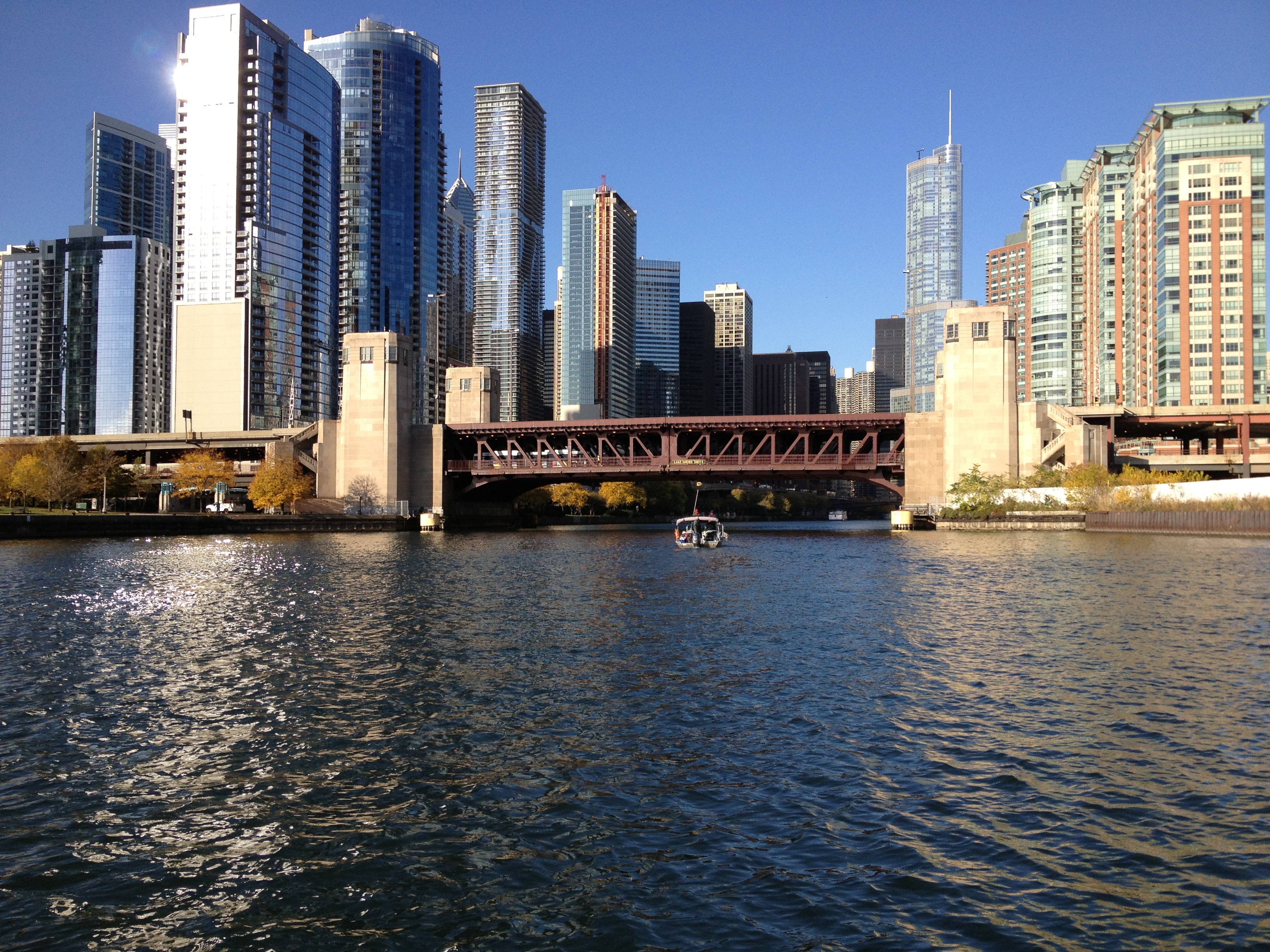 Chicago River, bridge and downtown skyscrapers under a clear blue sky.