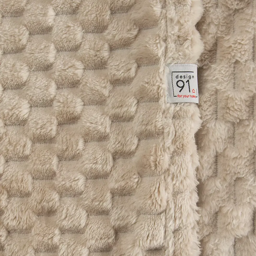 Thumbnail: The beige blanket is very soft to the touch, with a 3D embossed pattern.