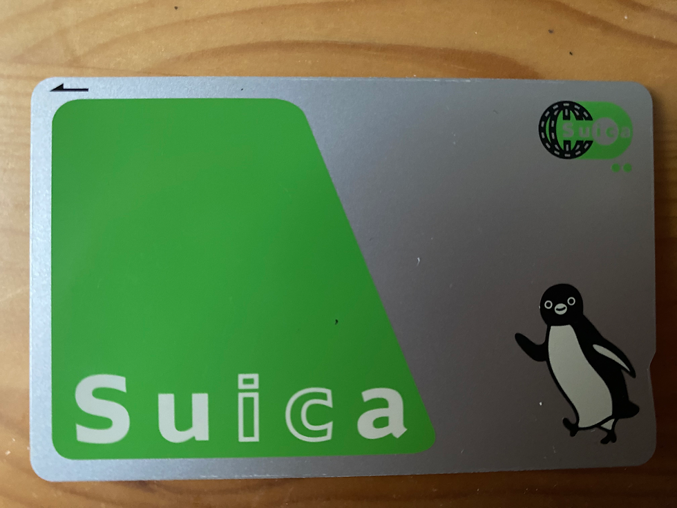 A Suica rail card that is green and silver and an icon of a penguin
