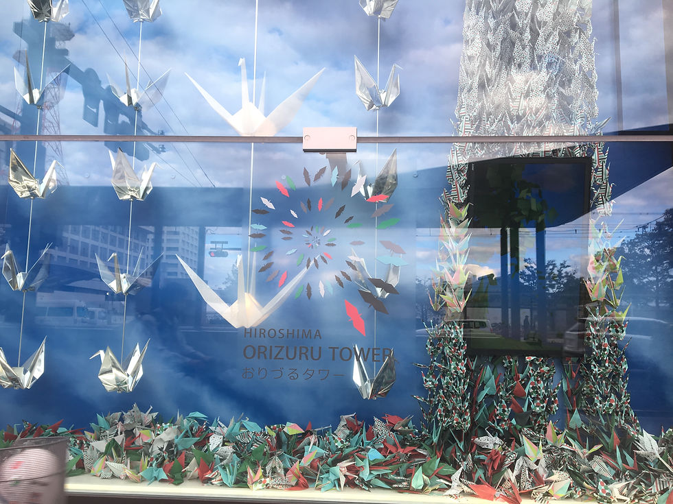 a display of origami cranes in piles or hanging