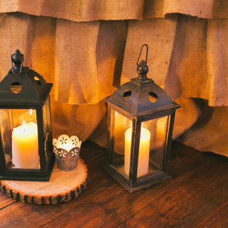 Lanterns on a wood slab. Rustic wedding decor.