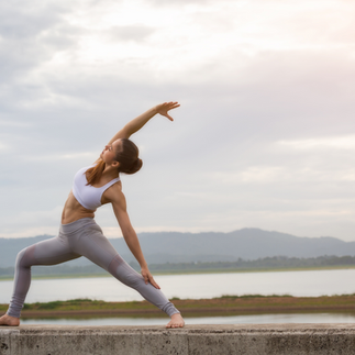 A bride is seen practicing self-care by engaging in exercise. She is dressed in athletic attire. The bride is stretching her body, with her arms extended upwards and her back slightly arched. 