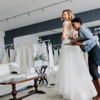 A woman in a wedding gown with a bridal stylist.