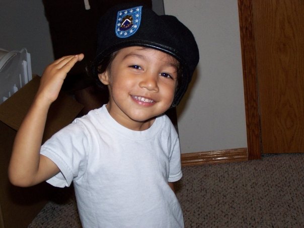 young child in father's military hat