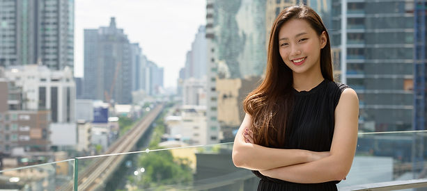 happy-young-beautiful-asian-businesswoman-smiling-with-arms-crossed-against-view-city_edit