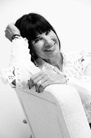 Zwart-wit portret van een lachende vrouw in stoel – fotoshoot bij Marye Photography