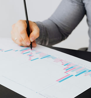 Person evaluating statistics on a sheet of paper with a pen to analyze performance