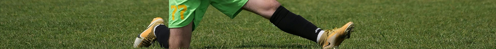 Man in football jersey doing static stretching to avoid injury