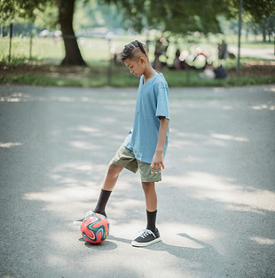Kind in blauem Shirt, das einen Ball annimmt