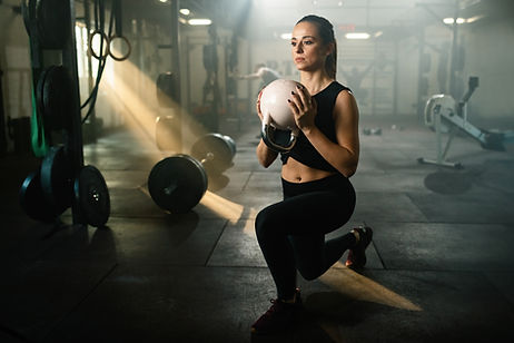 female-athlete-with-kettle-bell-practicing-lunge-on-cross-training-in-health-club.jpg