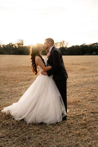 Brautpaar tanzt und küsst sich beim Sonnenuntergang auf einem Feld in Hameln Pyrmont