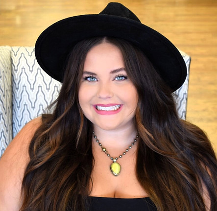 Smiling woman wearing a black hat and top, posing for the camera