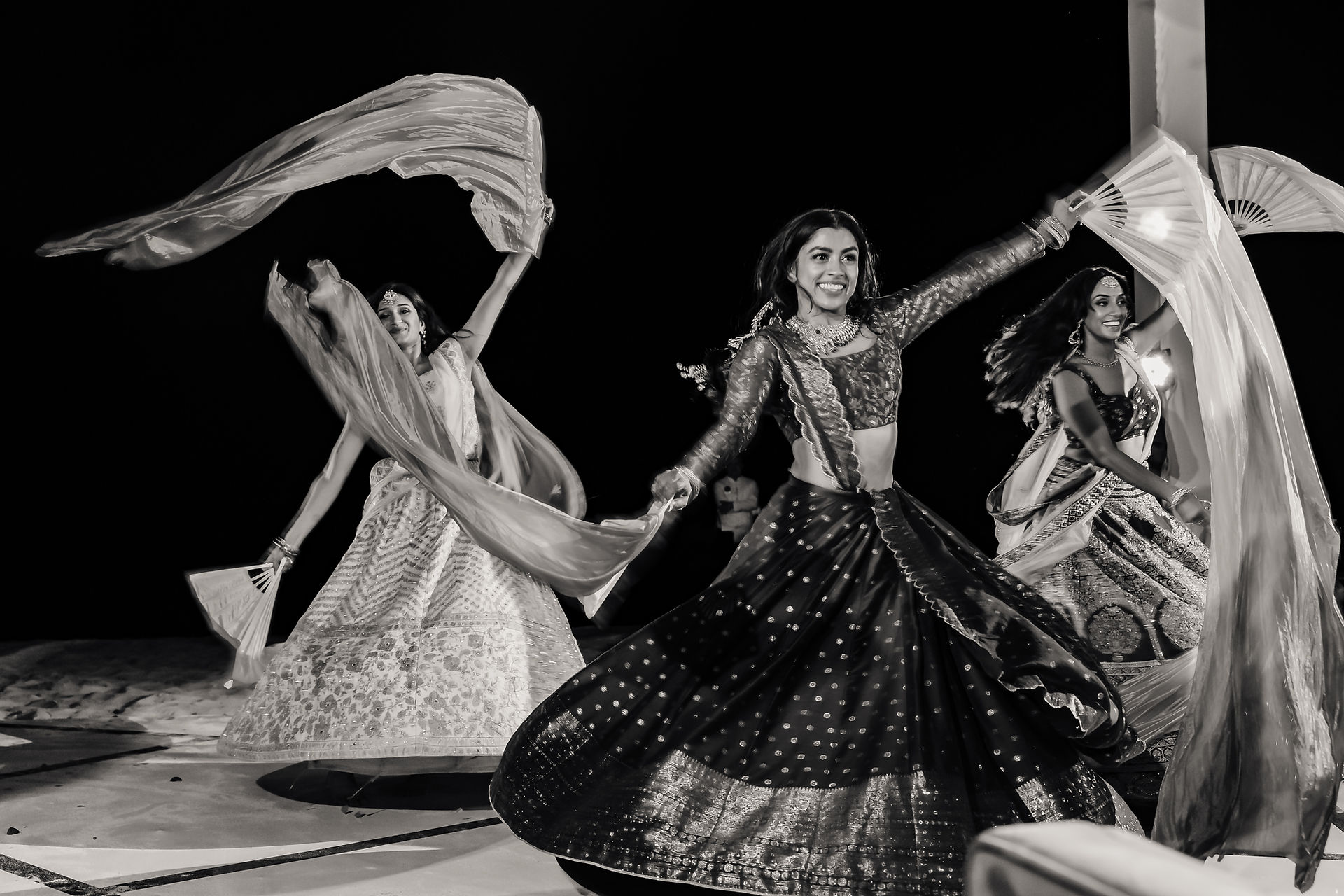 Bridesmaids perform a high-energy dance with flowing scarves during Bushra and Mohammed’s Sangeet night at Garza Blanca Puerto Vallarta, their lehengas twirling under the night sky.