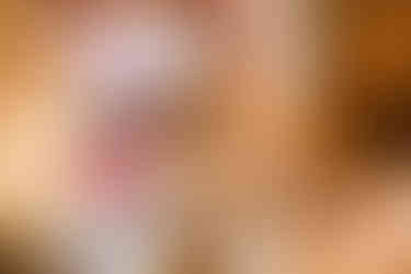 Close-up of a bride’s henna-adorned hand during the Haldi ceremony at Garza Blanca Cancun, as a loved one presses a yellow marigold flower onto her palm over turmeric paste