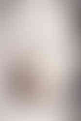 Groom in an embroidered white sherwani holding a personalized coconut drink engraved with “Rhia & Bhavik 12/14/2024” during their Garza Blanca Cancun destination wedding.