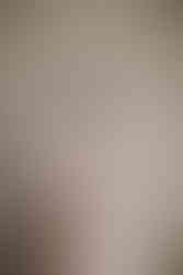 Bride Devina poses gracefully in a pastel floral embroidered lehenga with sheer dupatta, pearl and emerald choker, and traditional bangles. Her side profile highlights the intricate threadwork and soft blush tones of her outfit, captured before her Indian destination wedding at Moon Palace Cancún.