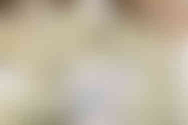 Grand white floral entrance arch leading to a luxurious Indian wedding mandap at Garza Blanca Cancun, framed by palm trees and modern architecture.